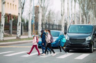school children cross the road in medical masks children go to school