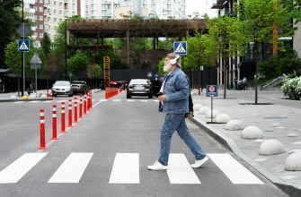 side view of older man crossing the street while listening to music on headphones
